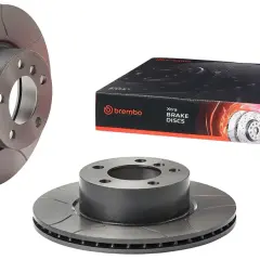 Trzy tarcze hamulcowe Brembo i pudełko z tarczami hamulcowymi.