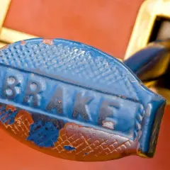 Stary, niebieski uchwyt hamulca z napisem "BRAKE". Zastanawiasz się, jaki smar do prowadnic hamulcowych?