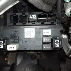 Skrzynka bezpieczników w Audi A3 8P. Widoczne przekaźniki i bezpieczniki, m.in. z oznaczeniami 460, 433, 395. Opis bezpieczników jest kluczowy.