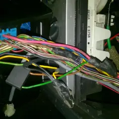 Plątanina przewodów w Opel Meriva, widoczny niebieski konektor i fragmenty instalacji elektrycznej, być może związane z lokalizacją bezpieczników.