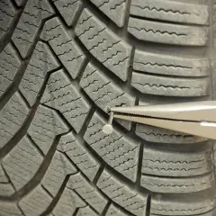 Wyjmowanie gwoździa z opony. Sprawdź, czy Twoja gwarancja na opony obejmuje takie uszkodzenia.