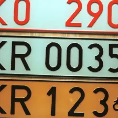 Różne kolory tablic rejestracyjnych w Polsce: białe, jasnoniebieskie i pomarańczowe. Widoczne numery to KO 2900, KR 00353, KR 123.