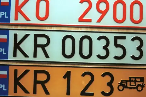 Różne kolory tablic rejestracyjnych w Polsce: białe, jasnoniebieskie i pomarańczowe. Widoczne numery to KO 2900, KR 00353, KR 123.
