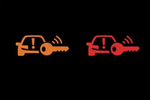Pomarańczowa i czerwona kontrolka auto z kluczem. Sygnalizują problem z immobilizerem lub kluczykiem.