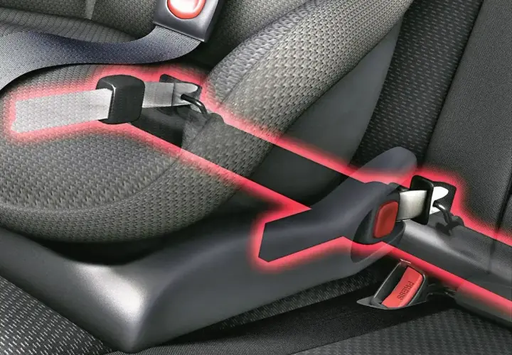 Widok z bliska na system ISOFIX w samochodzie, z czerwonymi liniami podkreślającymi punkty mocowania.
