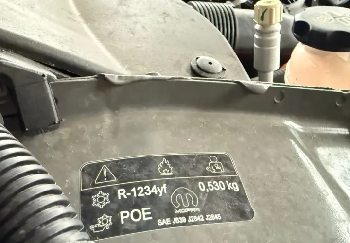 Naklejka pod maską informuje o czynniku chłodniczym R-1234yf, oleju POE i jego ilości 0,530 kg, zgodnie z normami SAE J639, J2842, J2845.