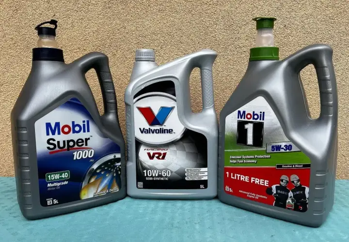Trzy bańki oleju silnikowego: Mobil Super 1000 15W-40, Valvoline VR1 10W-60 i Mobil 1 5W-30. Test olejów silnikowych 5w30.