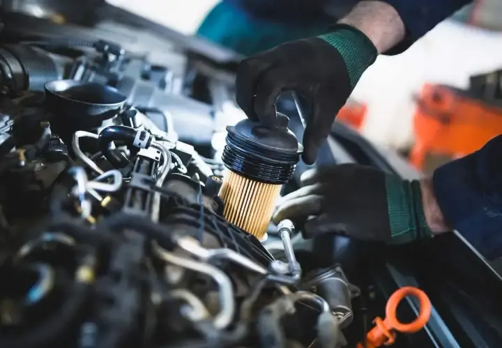 Mechanik wymienia filtr paliwa w silniku diesla. Zapchany filtr paliwa w dieslu objawy mogą być różne, od spadku mocy po problemy z uruchomieniem.