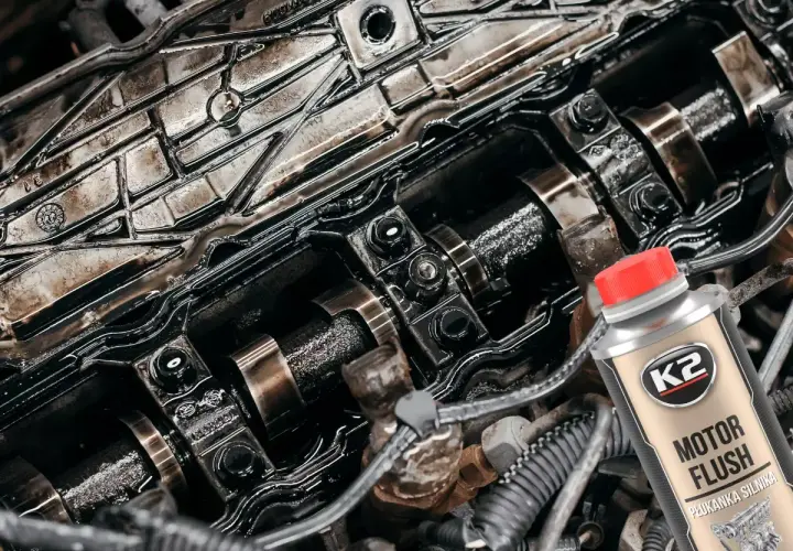 Wnętrze silnika po płukaniu ropą. Widać zabrudzone elementy i butelkę preparatu K2 Motor Flush.