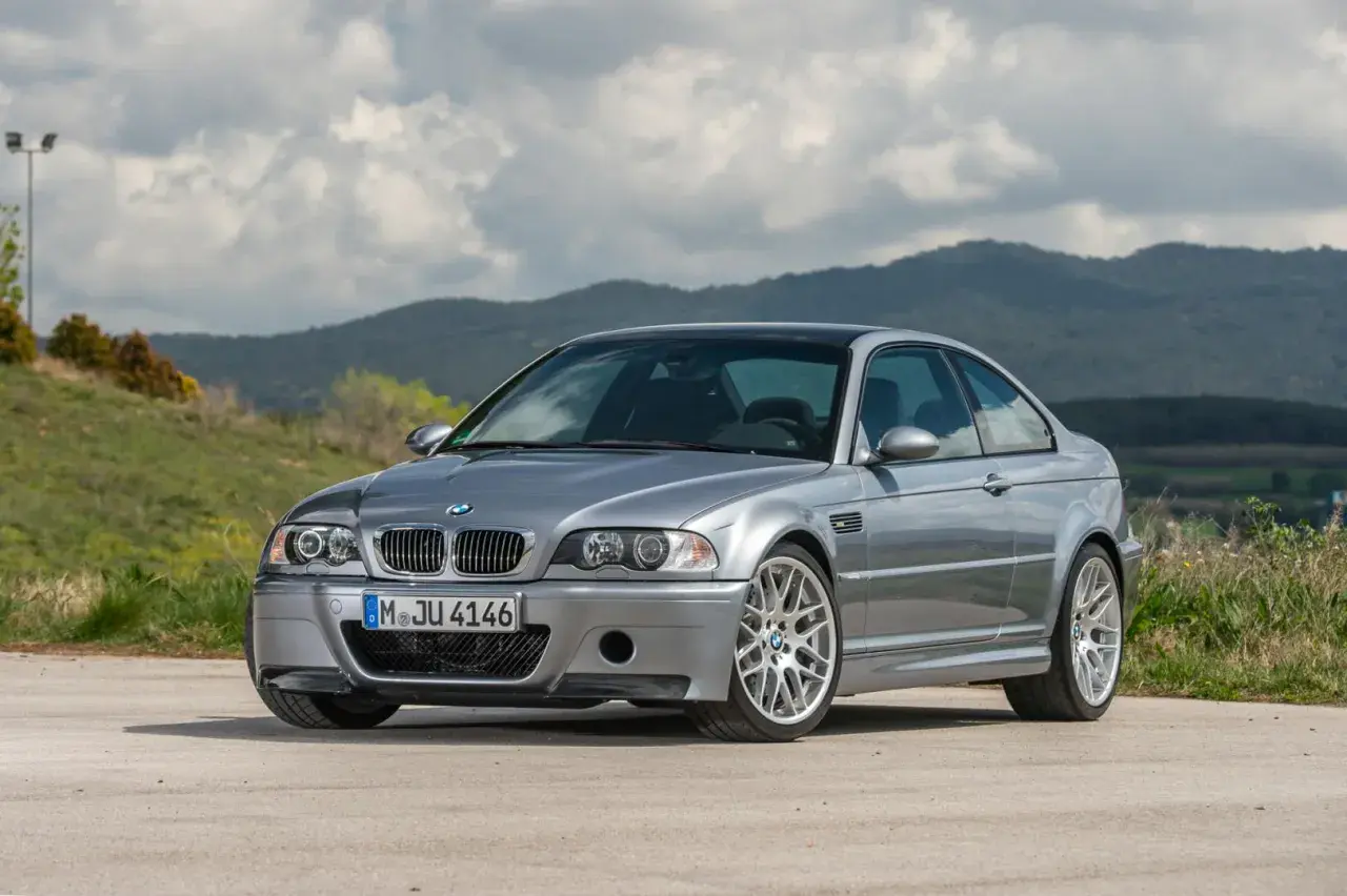 Srebrne BMW E46 coupe na tle górskiego krajobrazu.