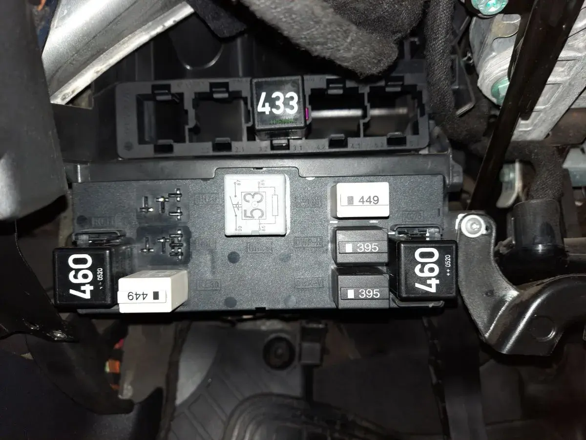 Skrzynka bezpieczników w Audi A3 8P. Widoczne przekaźniki i bezpieczniki, m.in. z oznaczeniami 460, 433, 395. Opis bezpieczników jest kluczowy.