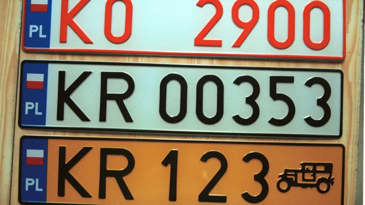 Różne kolory tablic rejestracyjnych w Polsce: białe, jasnoniebieskie i pomarańczowe. Widoczne numery to KO 2900, KR 00353, KR 123.