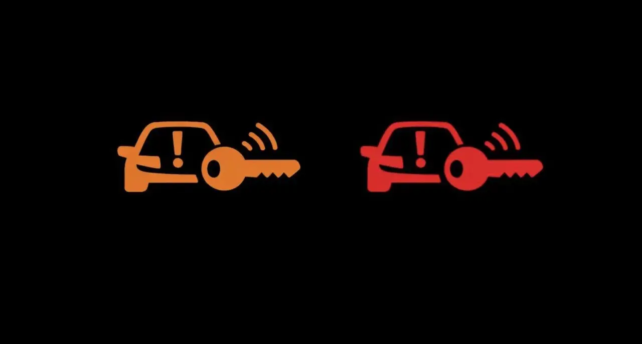 Pomarańczowa i czerwona kontrolka auto z kluczem. Sygnalizują problem z immobilizerem lub kluczykiem.