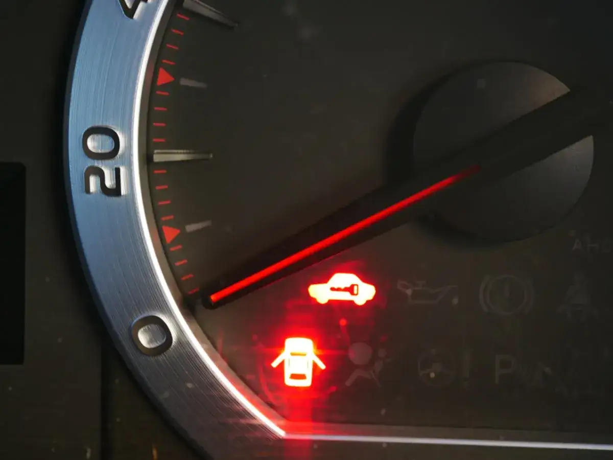 Na desce rozdzielczej świeci się kontrolka auto z kluczem i otwarta klapa bagażnika.
