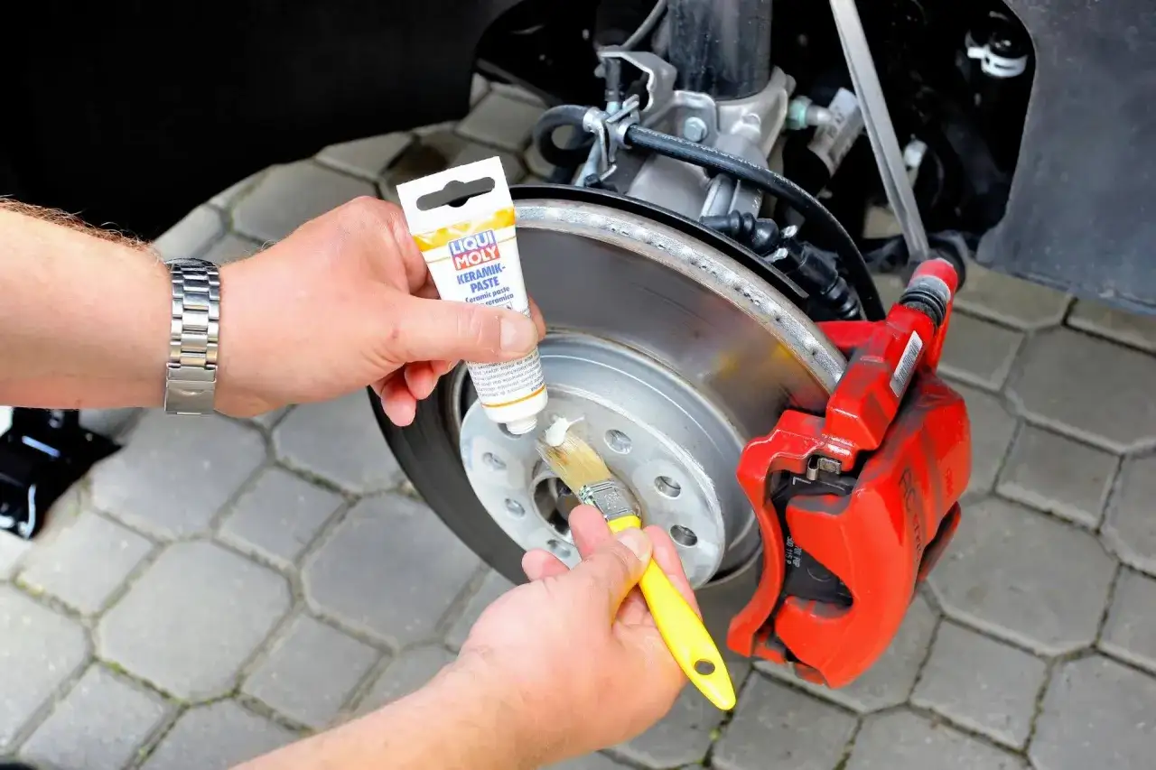 Aplikacja białego smaru ceramicznego Liqui Moly na piastę koła. Zastosowanie smaru zapewnia ochronę i płynne działanie hamulców.